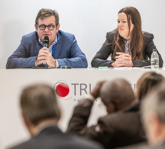 2 speakers sitting in front of attendees in the TRUSTECH conference room, talking about the revolution in instant payment