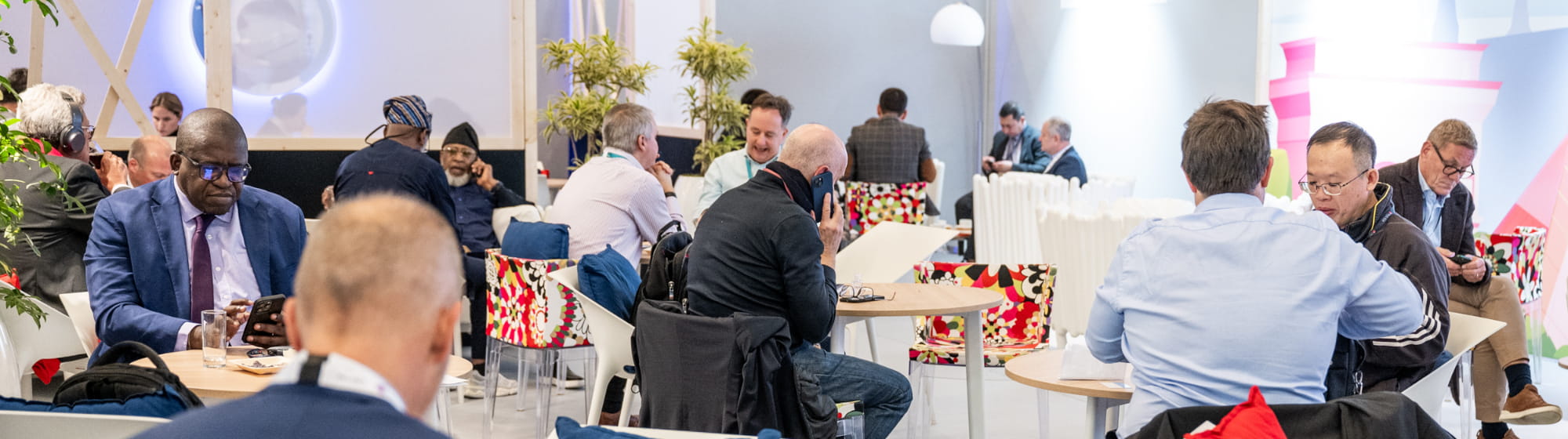 Professionals working or in a meeting in the TRUSTECH VIP Lounge.