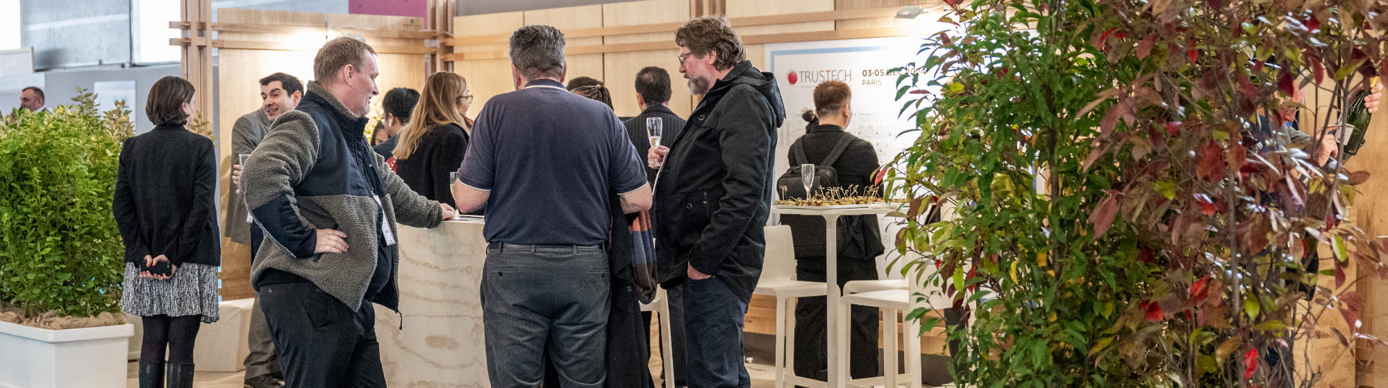 Visiteurs rencontrant d'autres personnes sur un stand décoré avec des arbres