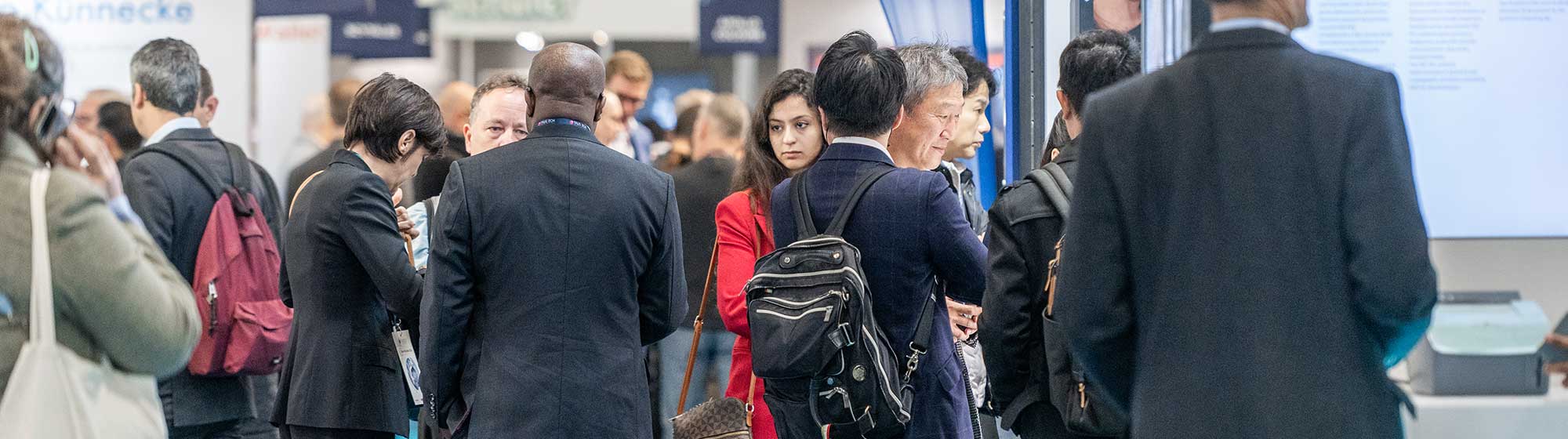 Visiteurs marchant dans les allées du salon Trustech