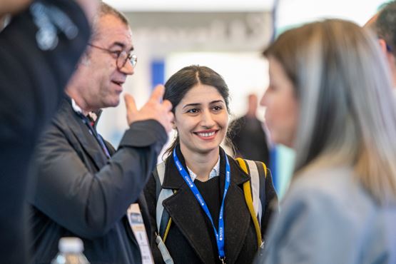 Visiteurs et exposant en discussion avec une femme souriante