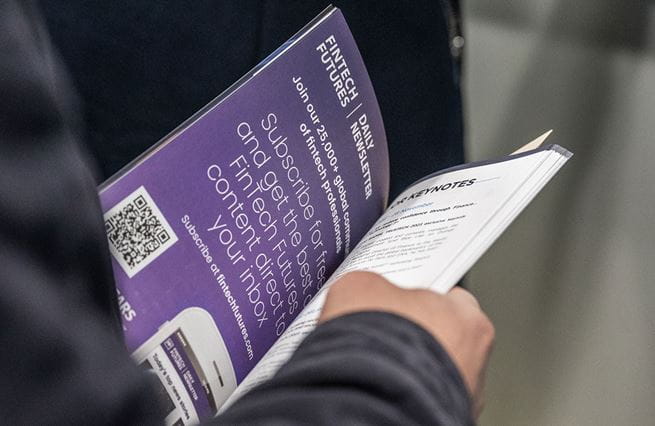 A visitor looking at the event catalogue, a fintech finance advertising is visible